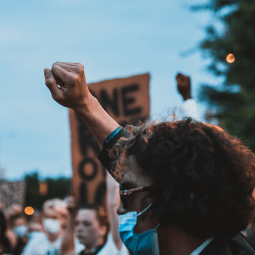 man at protest holding up his fist in solidarity