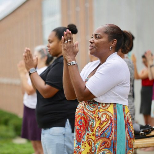 Women with their hands together in front of their faces