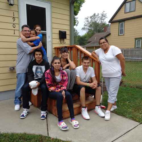 family standing in front of their house