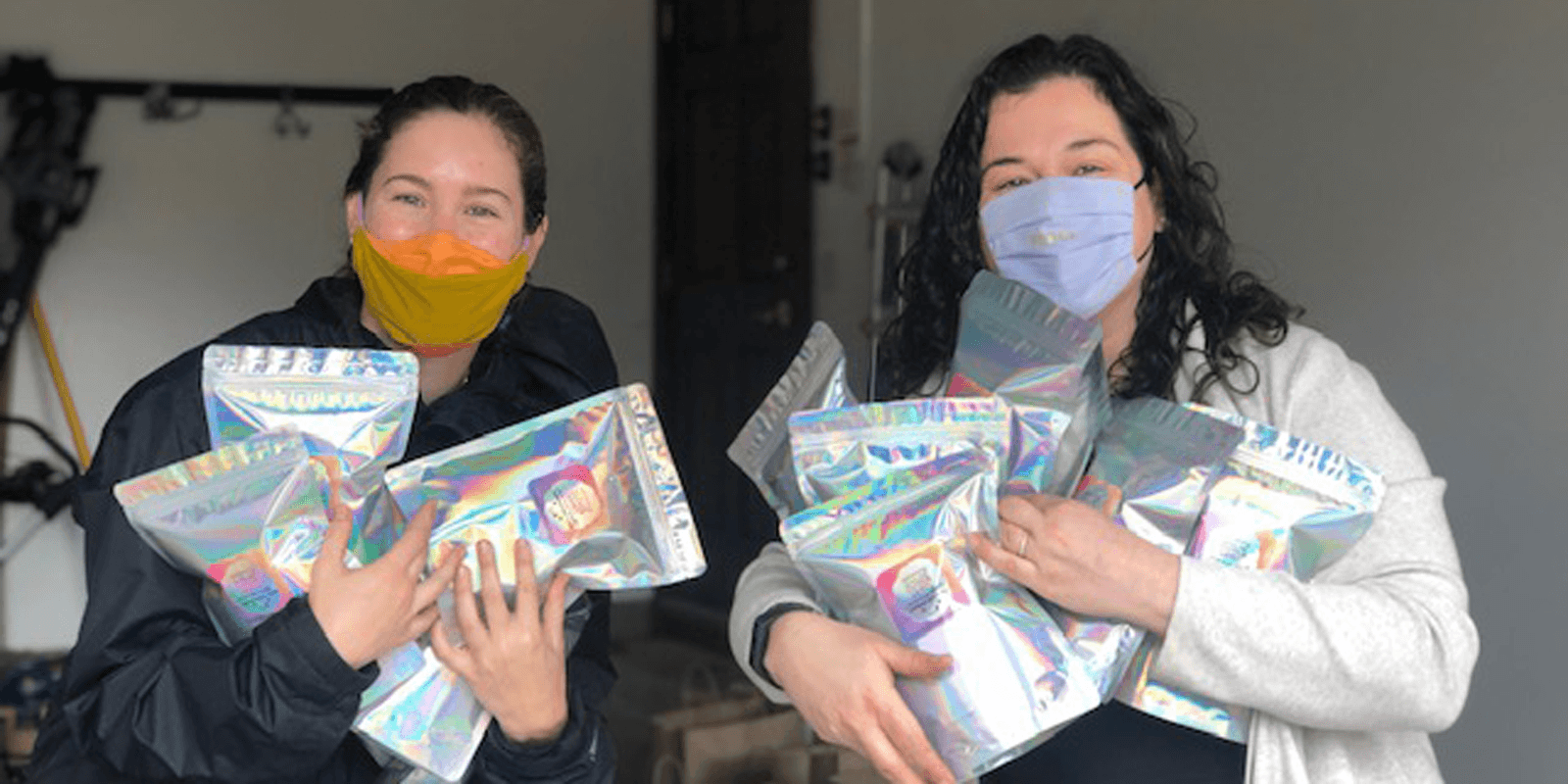 women in masks holding cotton candy