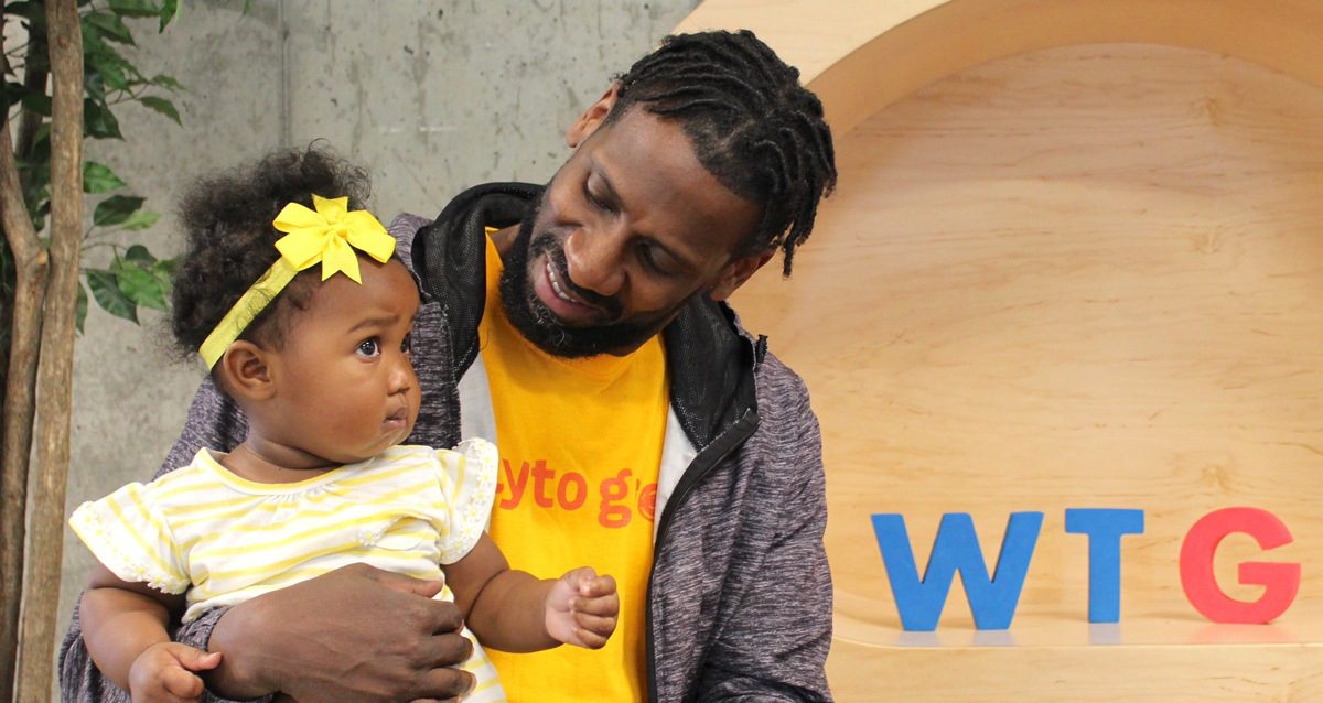 Black man holding infant daughter