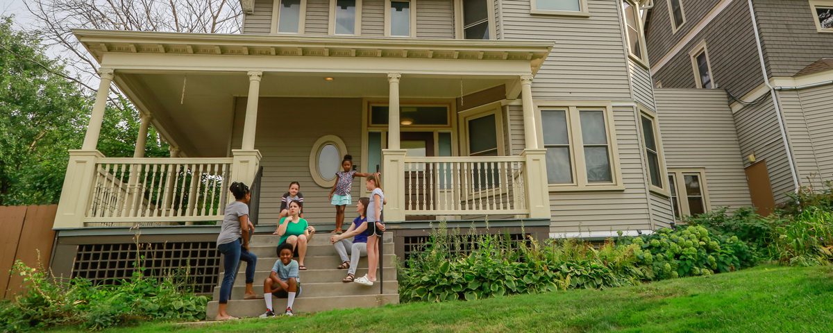 women and children sitting on a porch