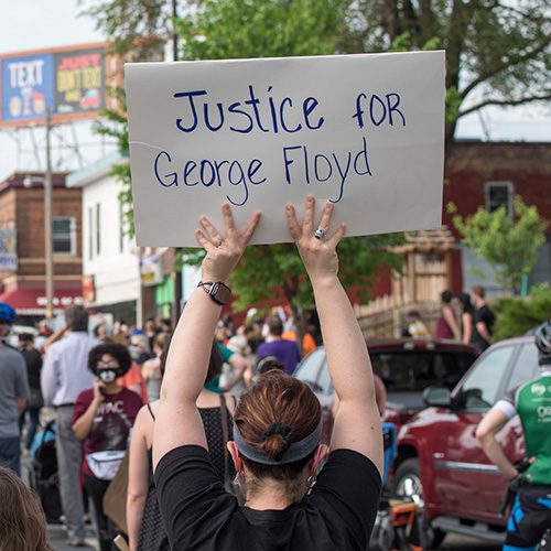Person holding sign that says, 