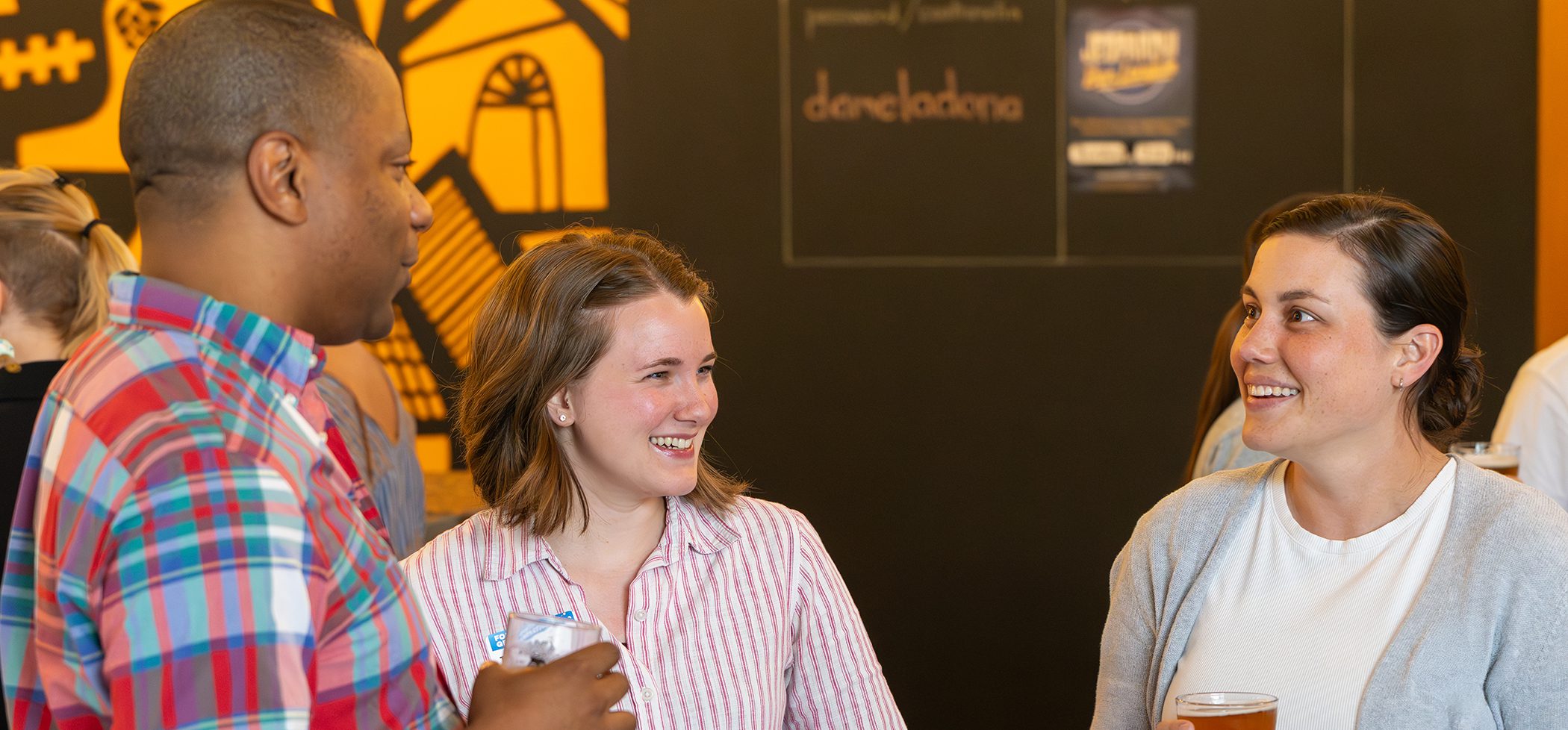 Three people having a conversation at a collective giving event